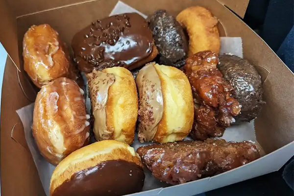 Three rows of donuts in a box lined with parchment paper | 1880 Mountain Industrial Blvd A1, Tucker, GA 30084