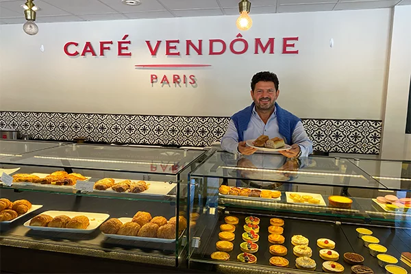 Man holding sandwich next to pastry display | 4969 Roswell Rd #155, Atlanta, GA 30342