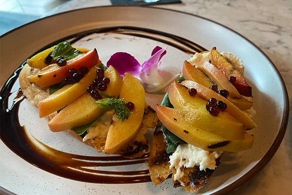 Two pieces of toast with slices of peach and a spread of cheese | 188 14th St NE, Atlanta, GA 30361